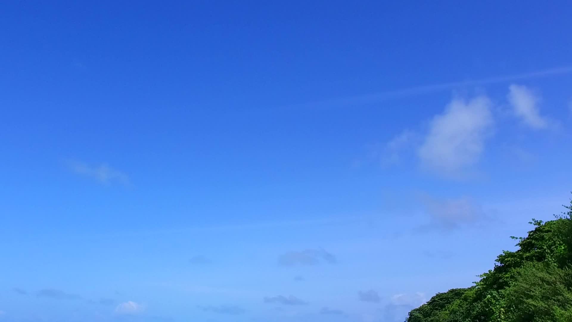 在太阳下山之前有一个蓝色的绿色环礁湖有一个白色的沙滩背景夏天和夏天的天空让视频的预览图