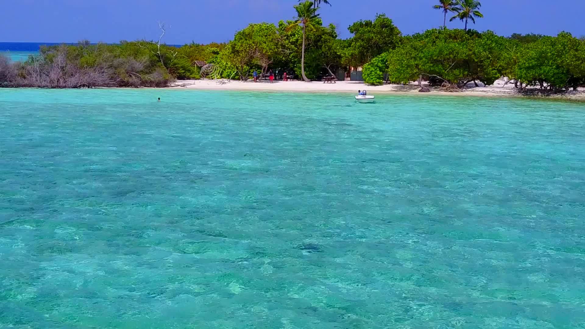由于阳光下清澈的海洋和白色的海滩背景完美的岛屿海滩被打破了视频的预览图