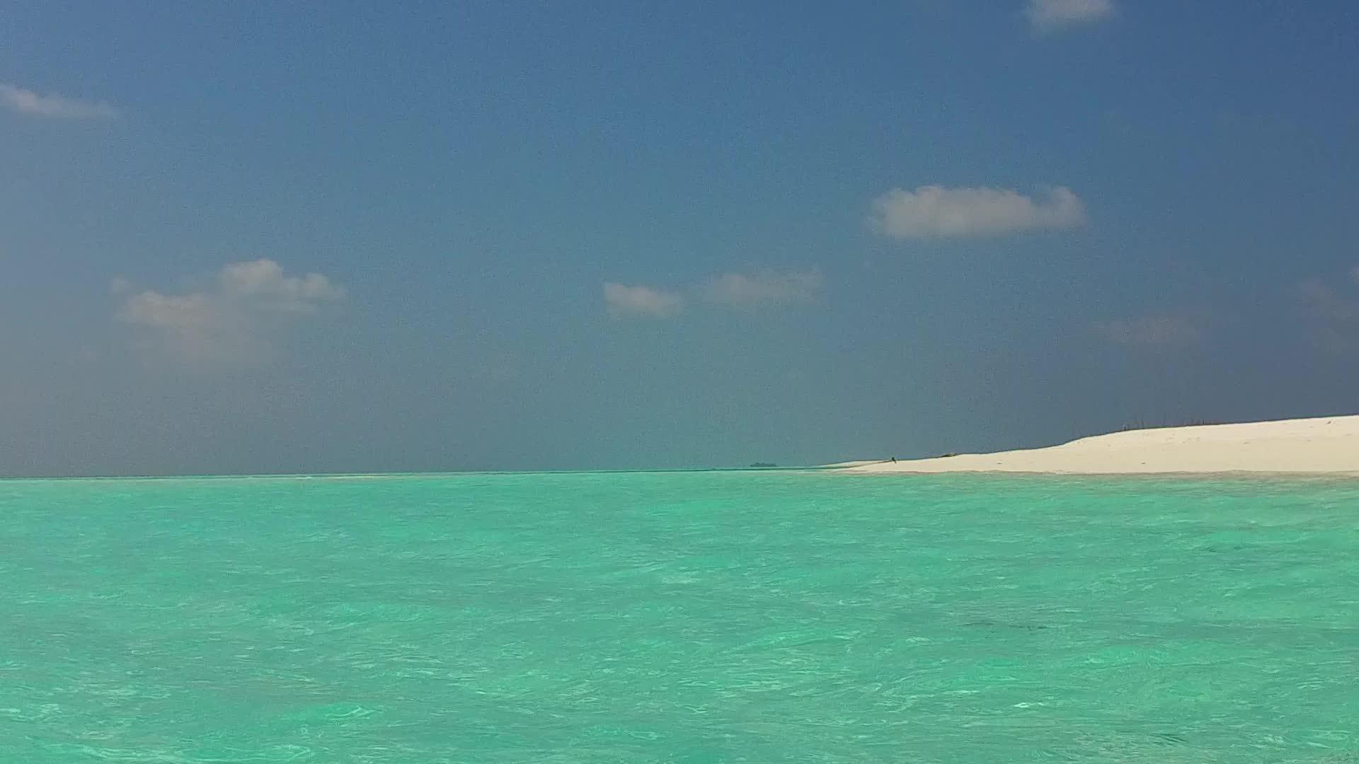 水蓝色的大海和阳光下干净的沙滩背景视频的预览图