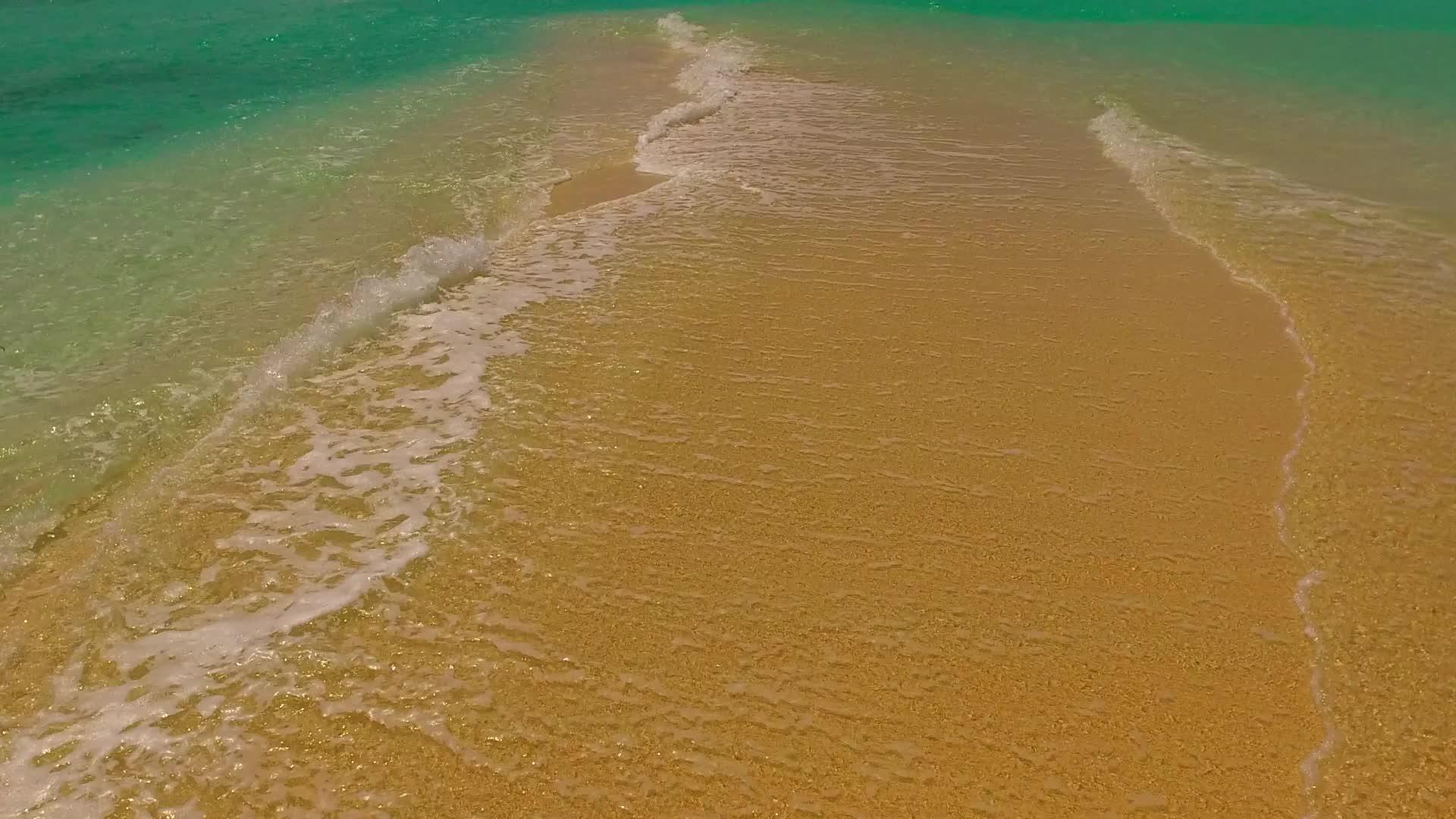 浅色的海水和白色的沙子在明亮的阳光下靠近沙洲视频的预览图