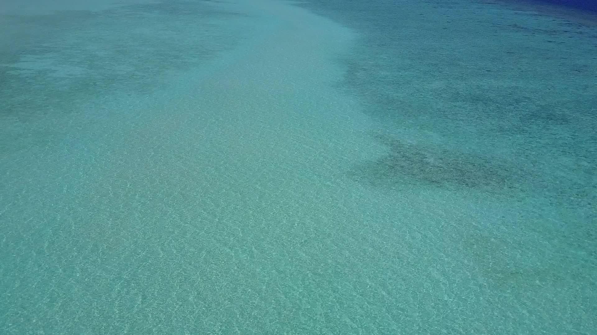 度假胜地附近的蓝绿色环礁湖呈现出白沙的背景视频的预览图