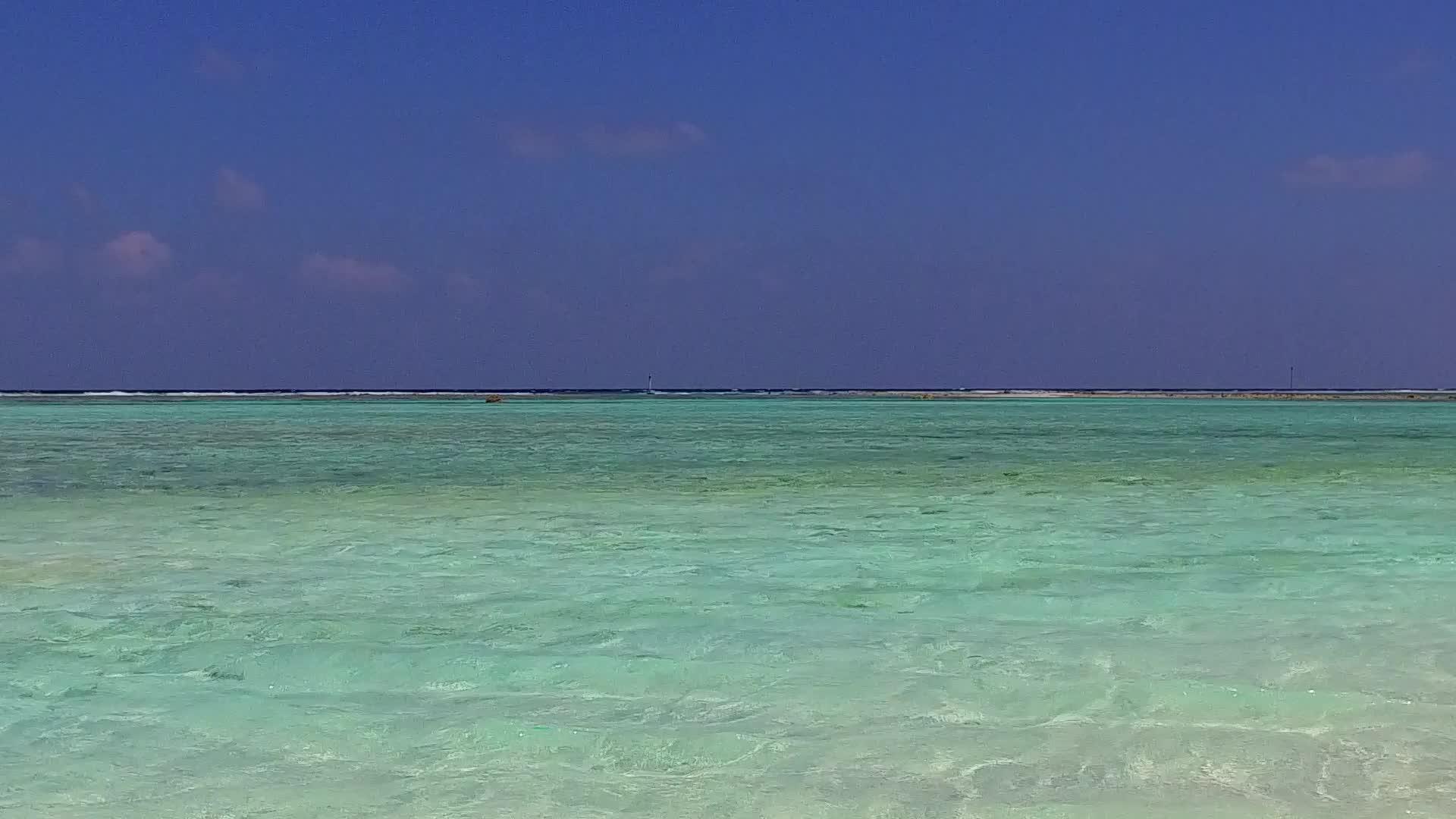 浅海和海浪附近的浅沙背景明亮的蓝色海洋度假村海滩旅游视频的预览图