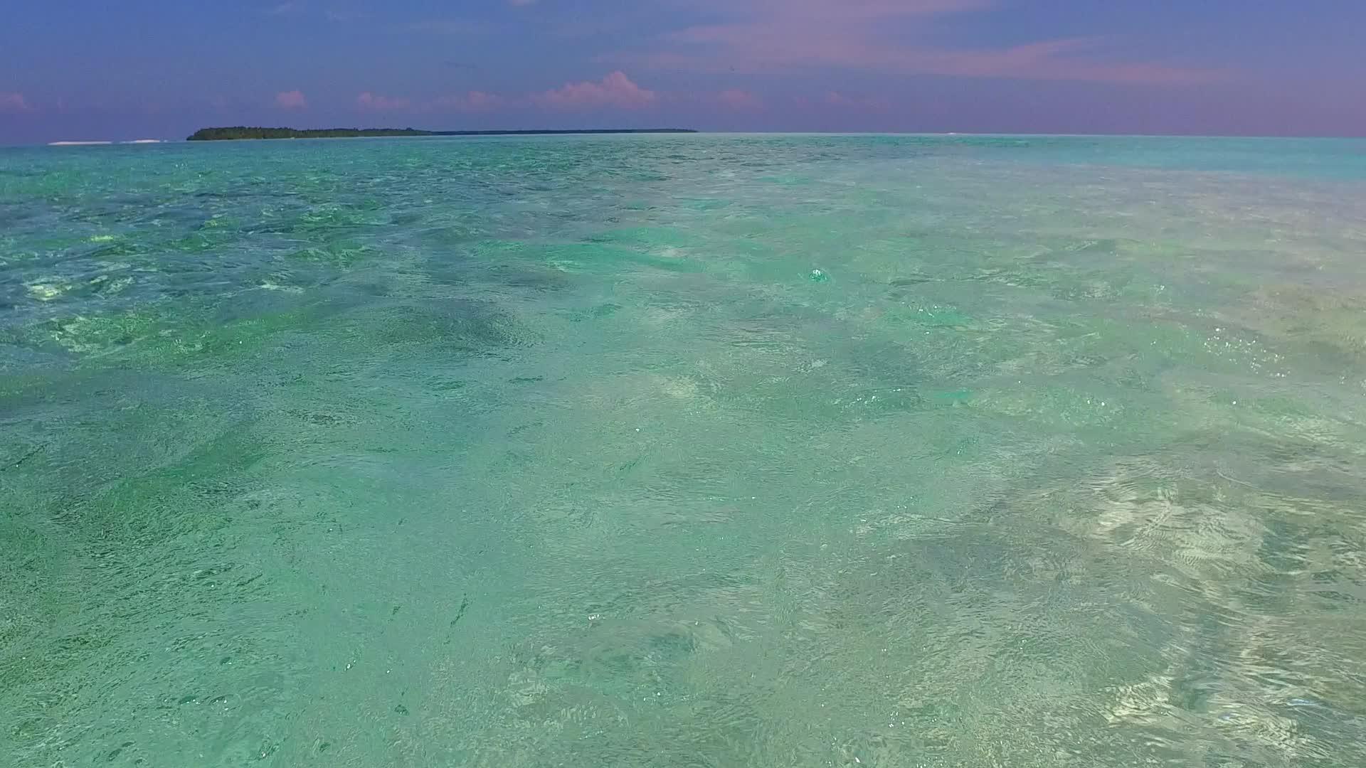 日落前蓝色环礁漂浮在黄昏中背景为蓝色环礁和白色沙子视频的预览图