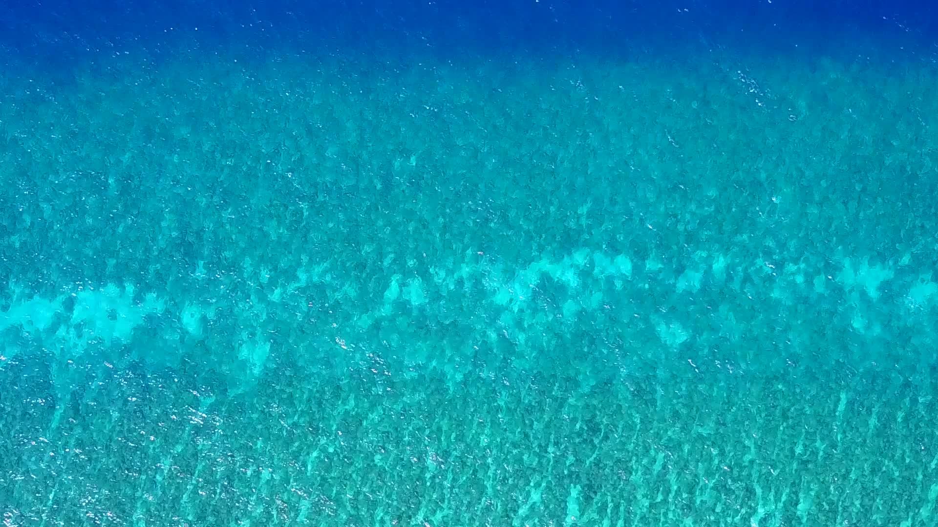 由于蓝海和接近冲浪的白沙背景环礁湖周围的豪华海滩被打破视频的预览图