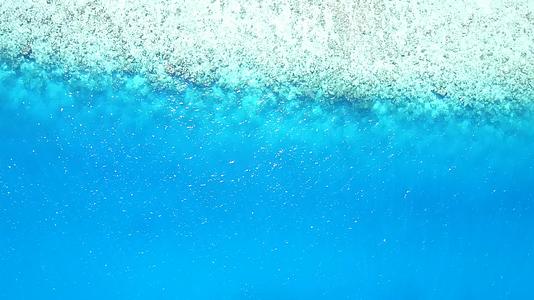 以海蓝水和阳光下的白沙为例以海滨海滩之旅的温暖风景为例视频的预览图
