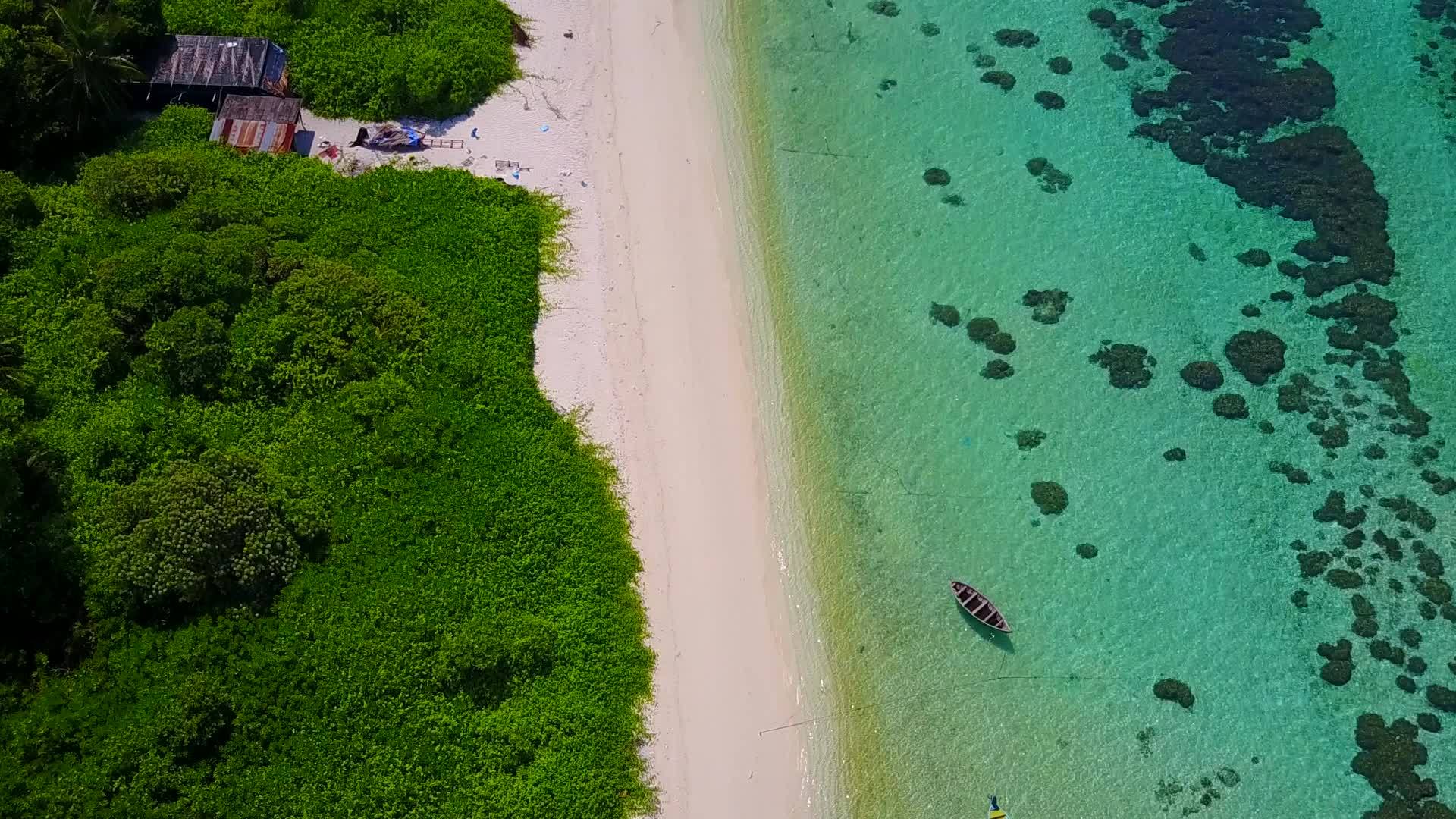 在海浪附近有白色沙子的海平面上穿过蓝色的海滨海滩视频的预览图