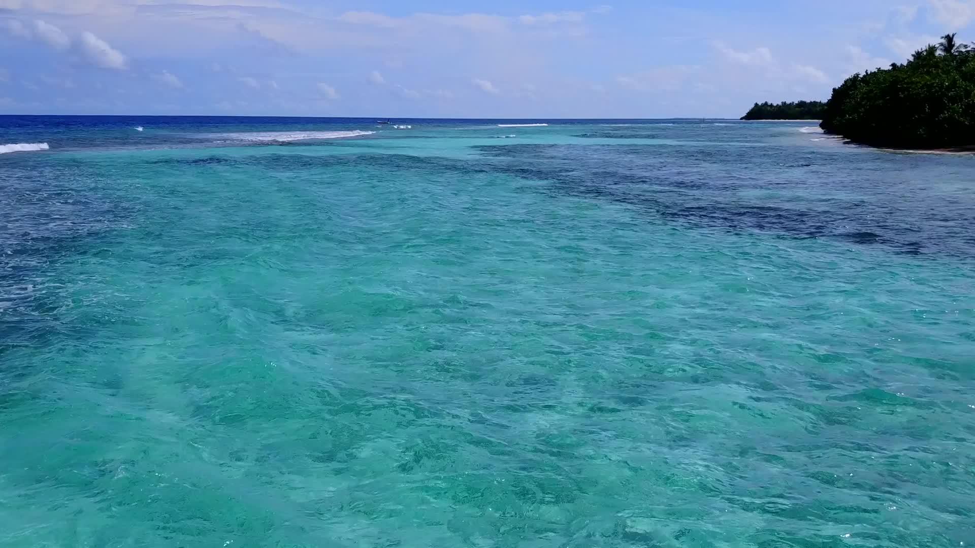 在阳光下有白色沙子背景的海平面上海湾穿过蓝色的水海视频的预览图