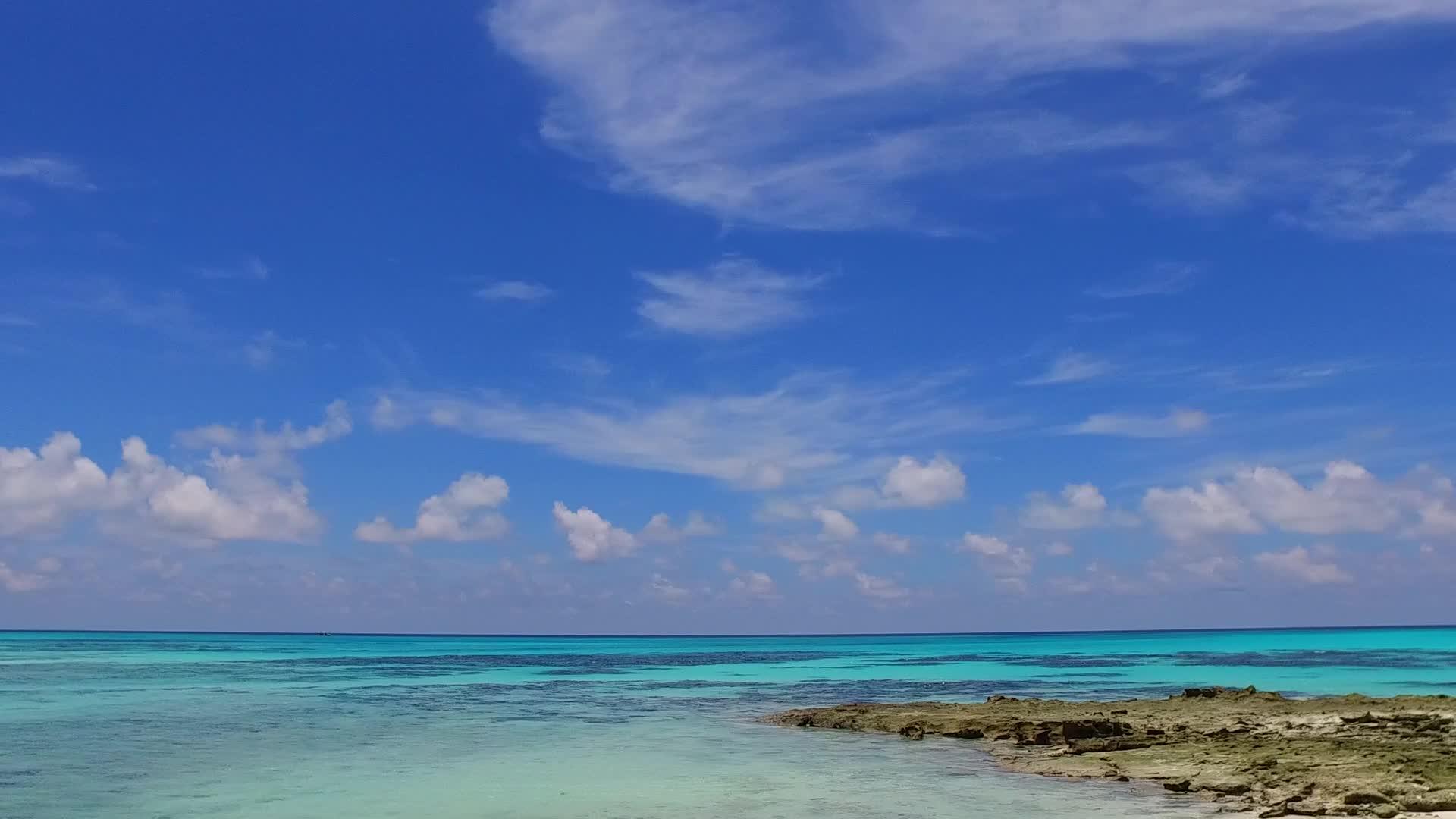 天堂度假村海滩度假近景浅海白沙背景阳光下视频的预览图