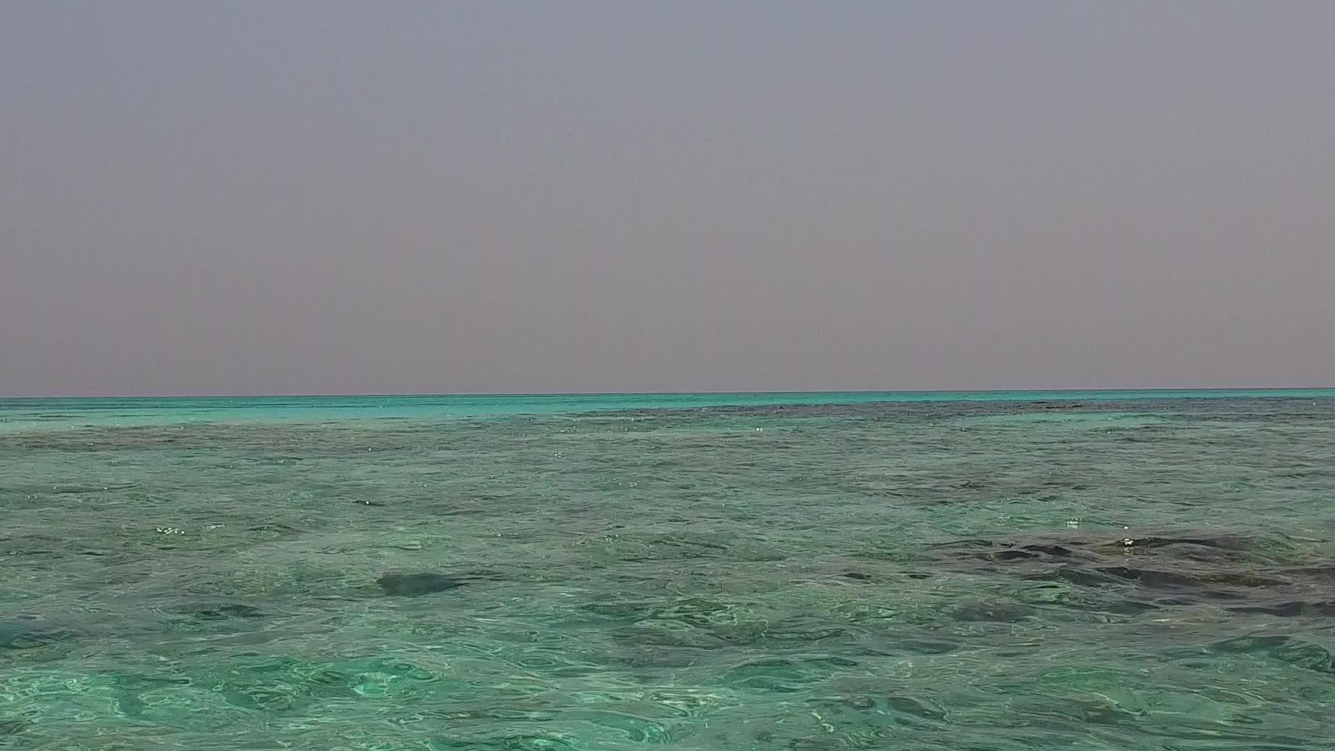 清澈的海水和接近冲浪的白色海滩背景视频的预览图