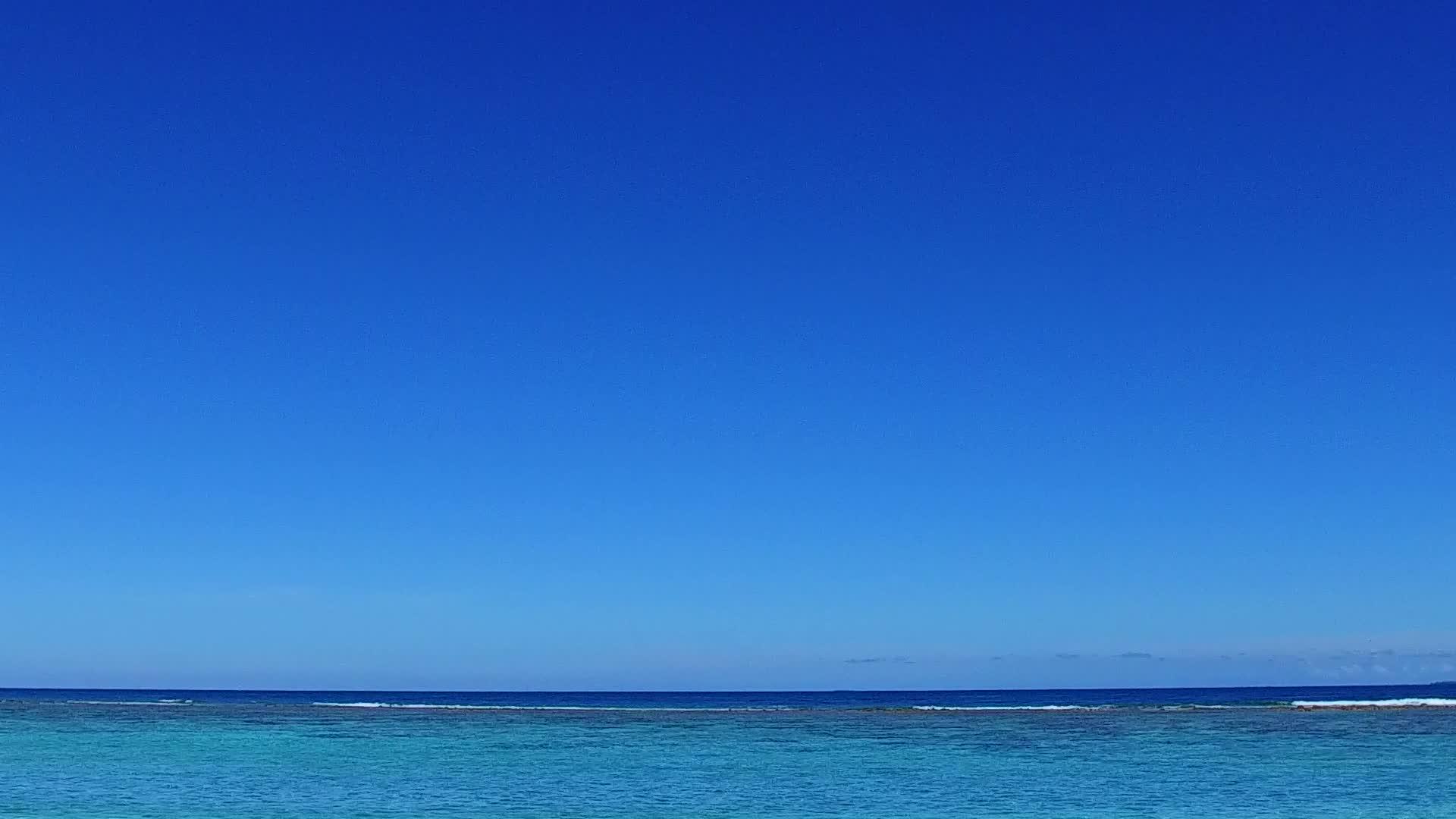 蓝色环礁湖和海边白色海滩背景的海洋旅游海滩假日阳光明媚视频的预览图