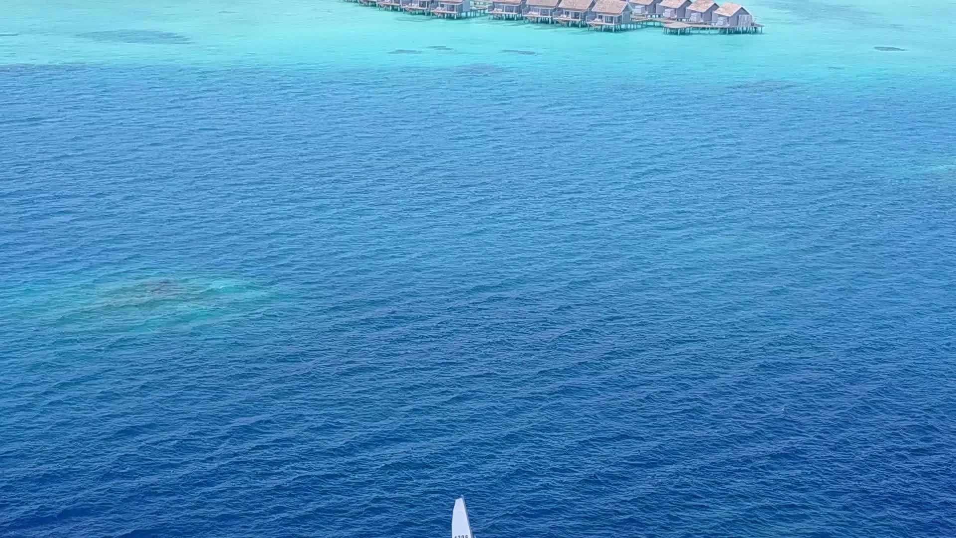 在蓝色的海洋中度假胜地附近有一个白色的沙底背景视频的预览图