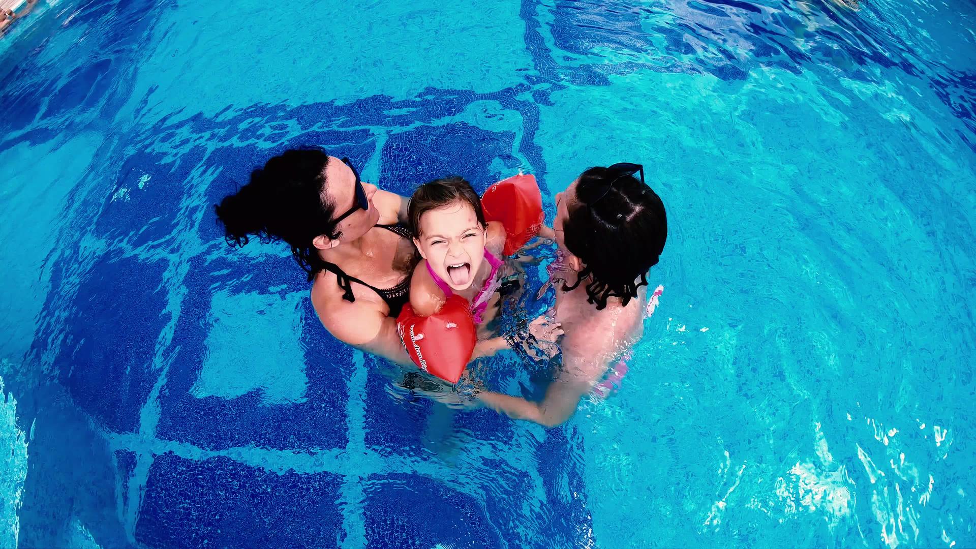 家庭母亲和女儿在豪华游泳池的鸟瞰图中玩耍Thay伸出视频的预览图