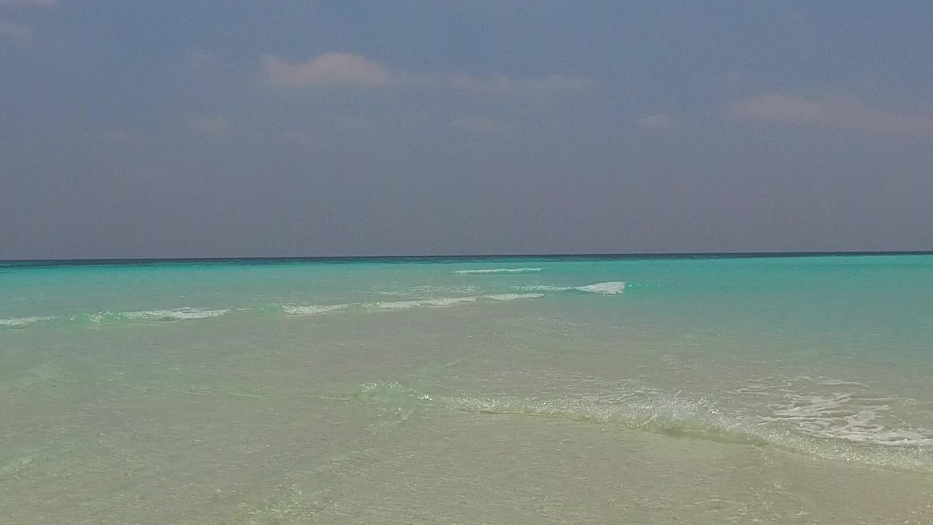 通过清晰的环礁湖靠近度假假胜地附近有一个白色的沙底背景使天堂的背景视频的预览图