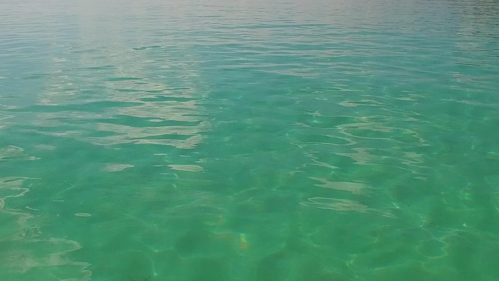 海浪附近明亮的沙质背景的水蓝色泻湖是完美的旅游海滩视频的预览图