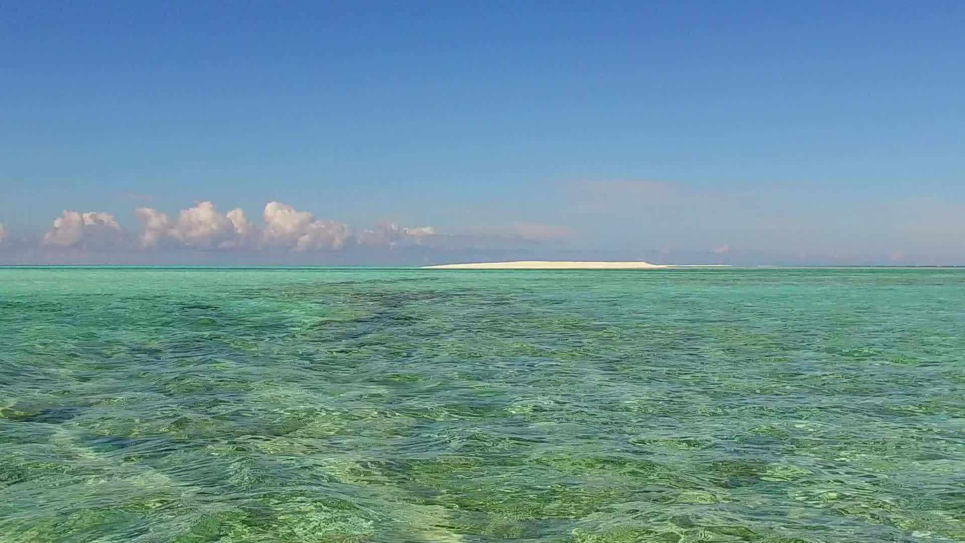沿海海岸呈现的蓝色环礁湖和接近冲浪的白色沙滩背景视频的预览图