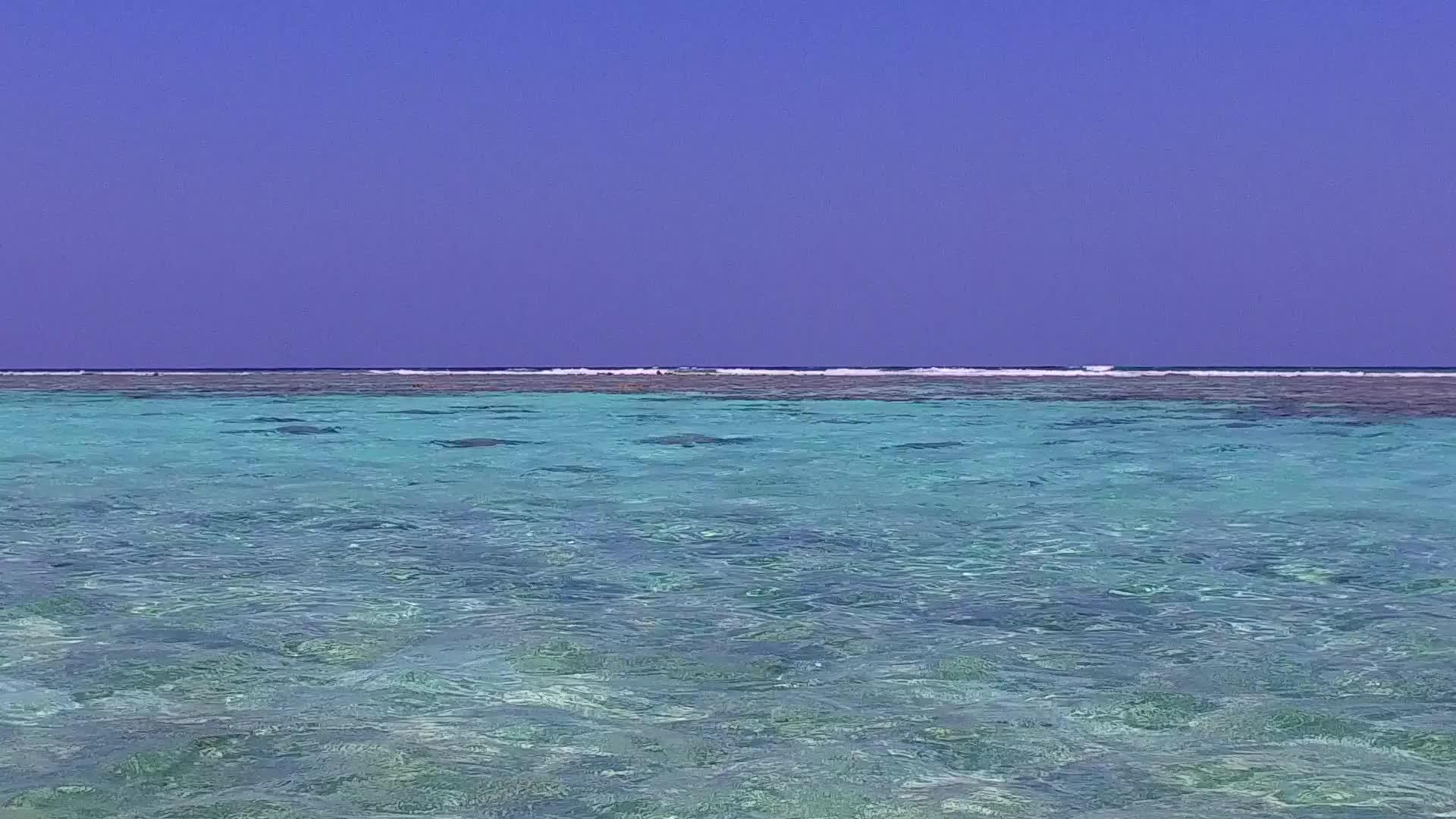 放松蓝色环礁湖和度假胜地附近的白色海滩背景视频的预览图