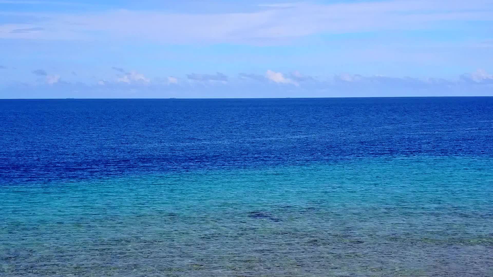 阳光明媚的豪华海滩风景在度假胜地附近的蓝水和白沙视频的预览图