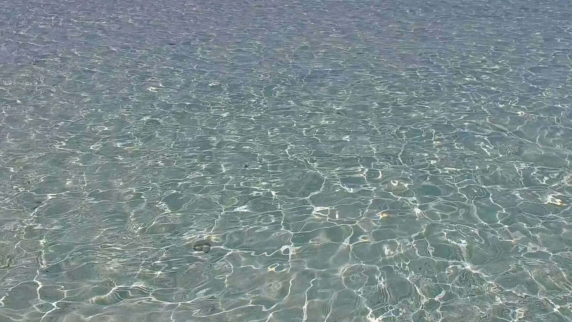 通过透明的海洋和靠近度假胜地的白色海滩胜地附近的白色海滩展示视频的预览图
