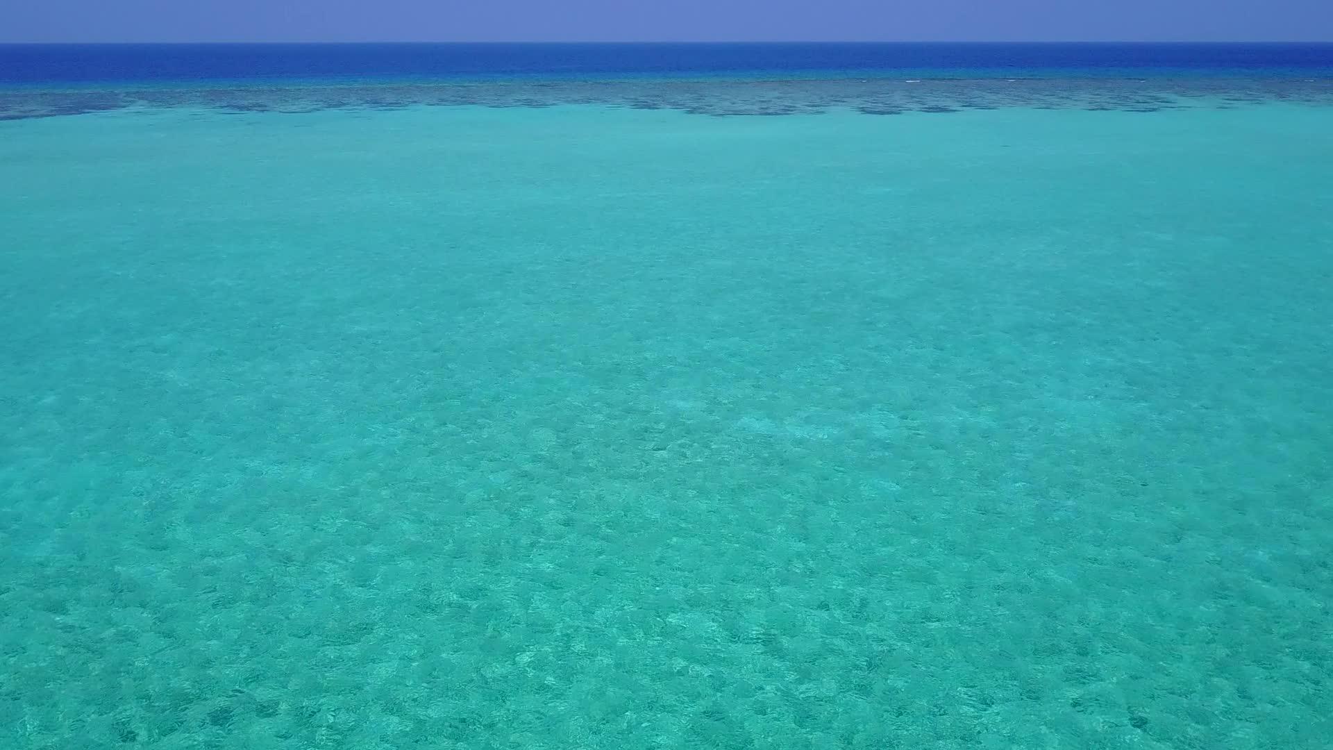 阳光明媚的景象是海蓝海海浪附近有白色的沙沙背景视频的预览图