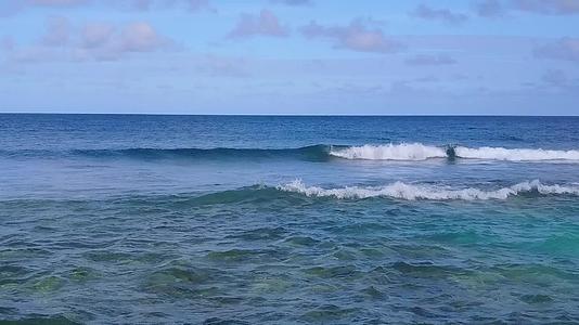 冲浪附近有蓝色泻湖异国度假海滩野生动物的白色沙滩背景视频的预览图