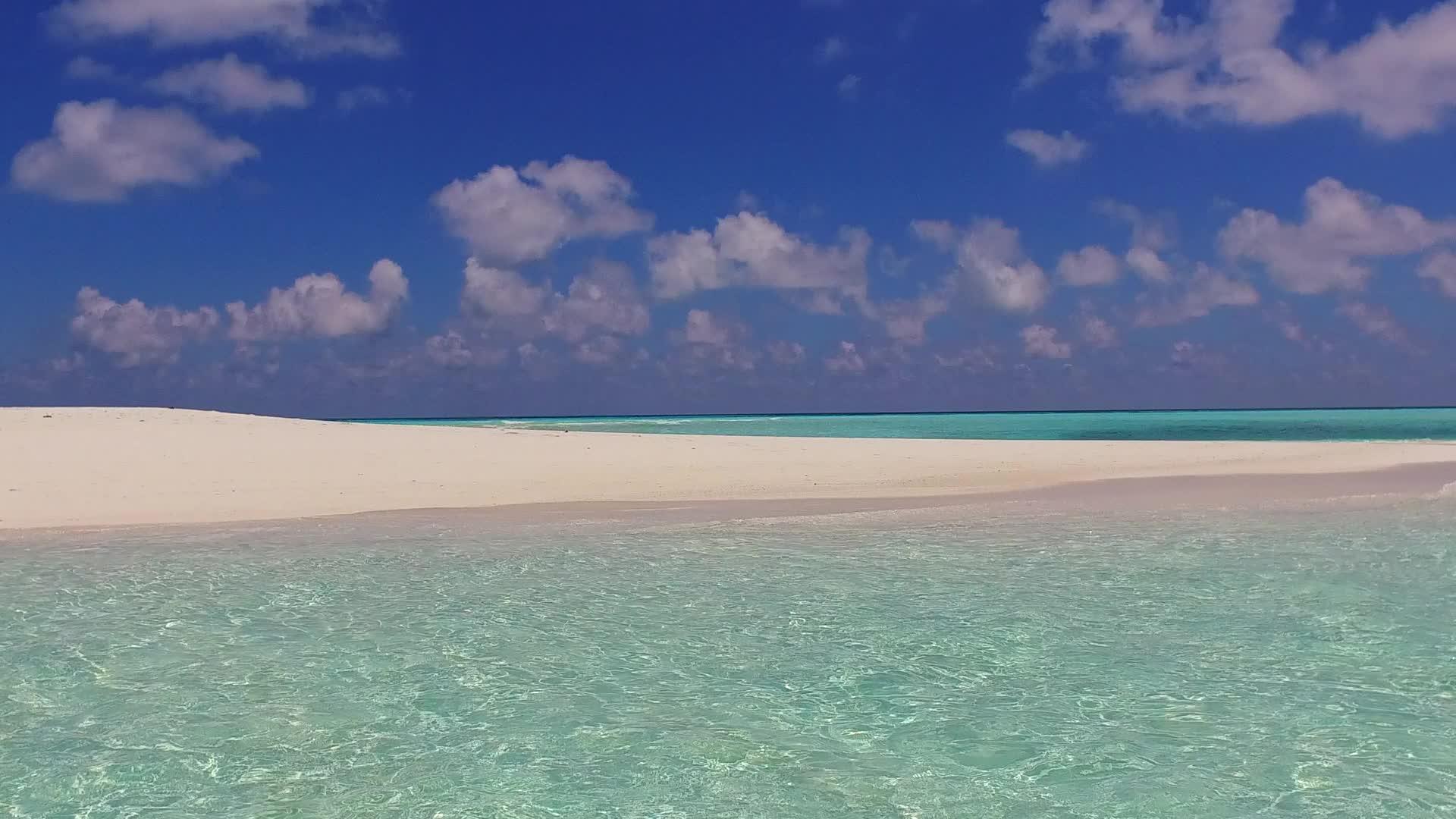 阳光下的蓝色环礁湖白色沙子的背景视频的预览图