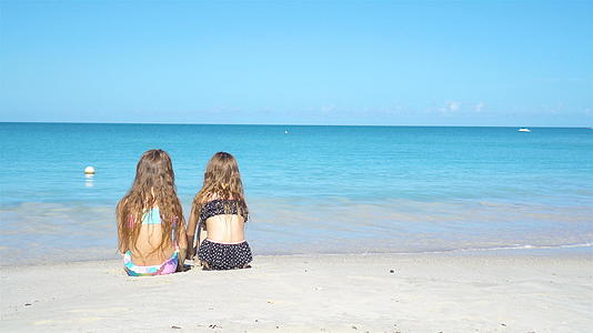 暑假期间可爱的小姐妹们在海滩上度假视频的预览图