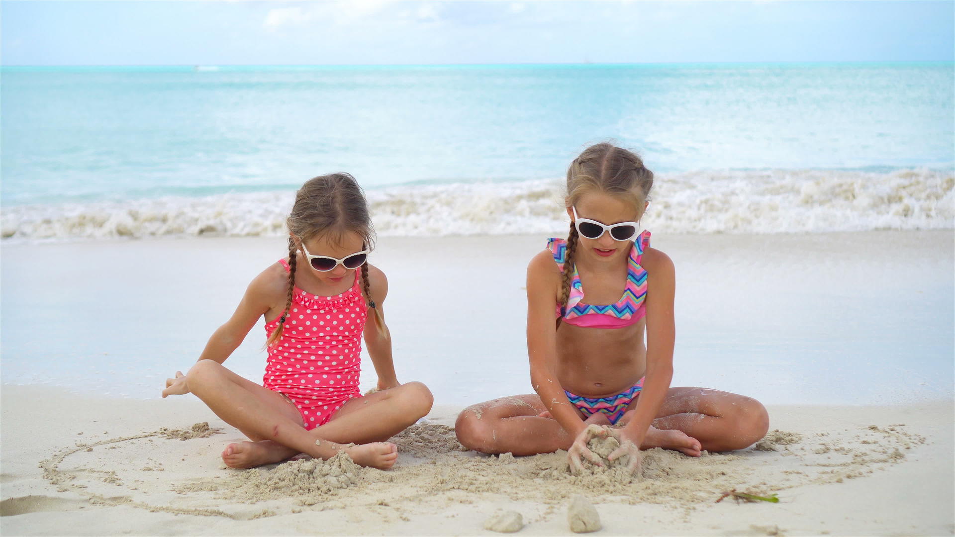 这个可爱的小女孩在海滩上玩得很开心两个漂亮的孩子在海边玩得很开心视频的预览图