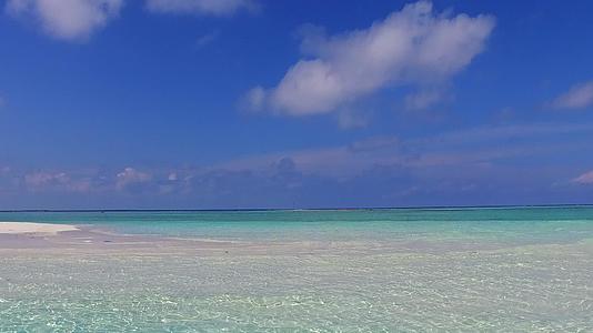 蓝色环礁湖和棕榈树附近白色沙滩背景的浪漫风景视频的预览图