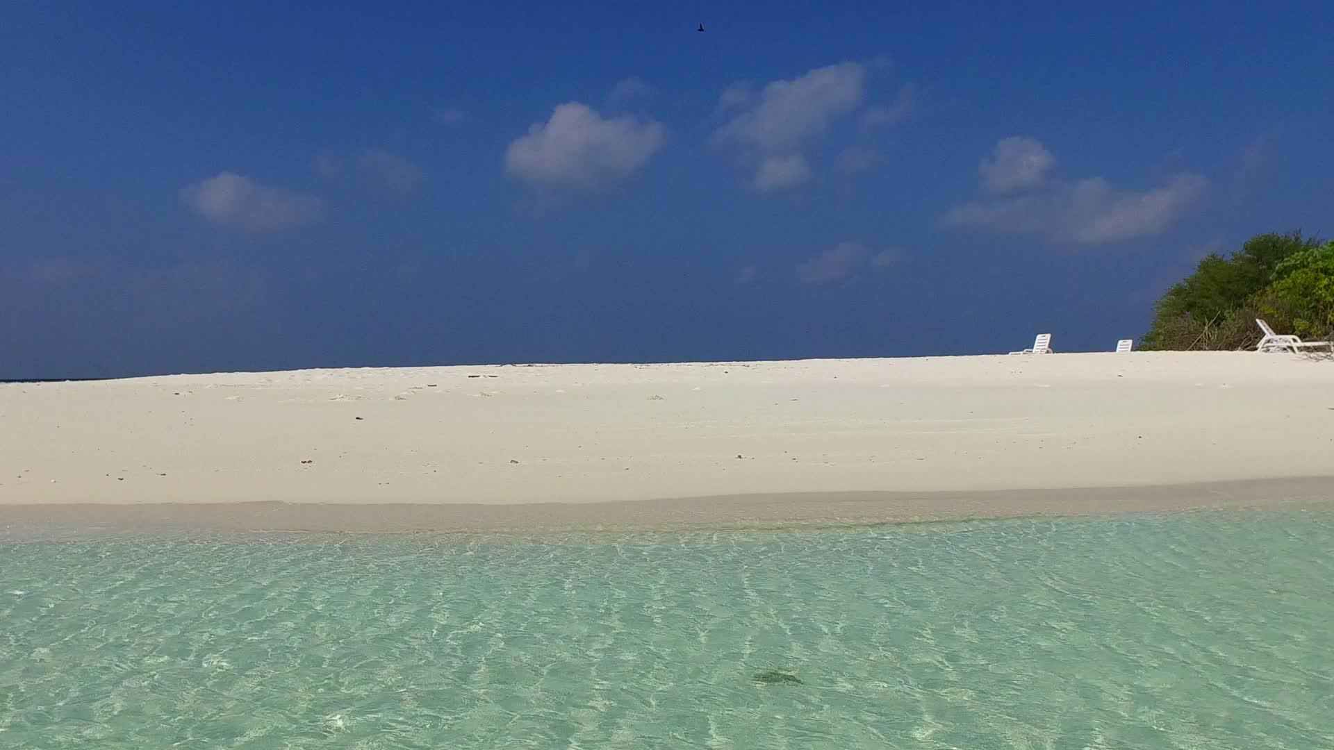 由蓝色环礁湖在沙巴附近的浅蓝色海滩上有明亮的沙滩背景视频的预览图