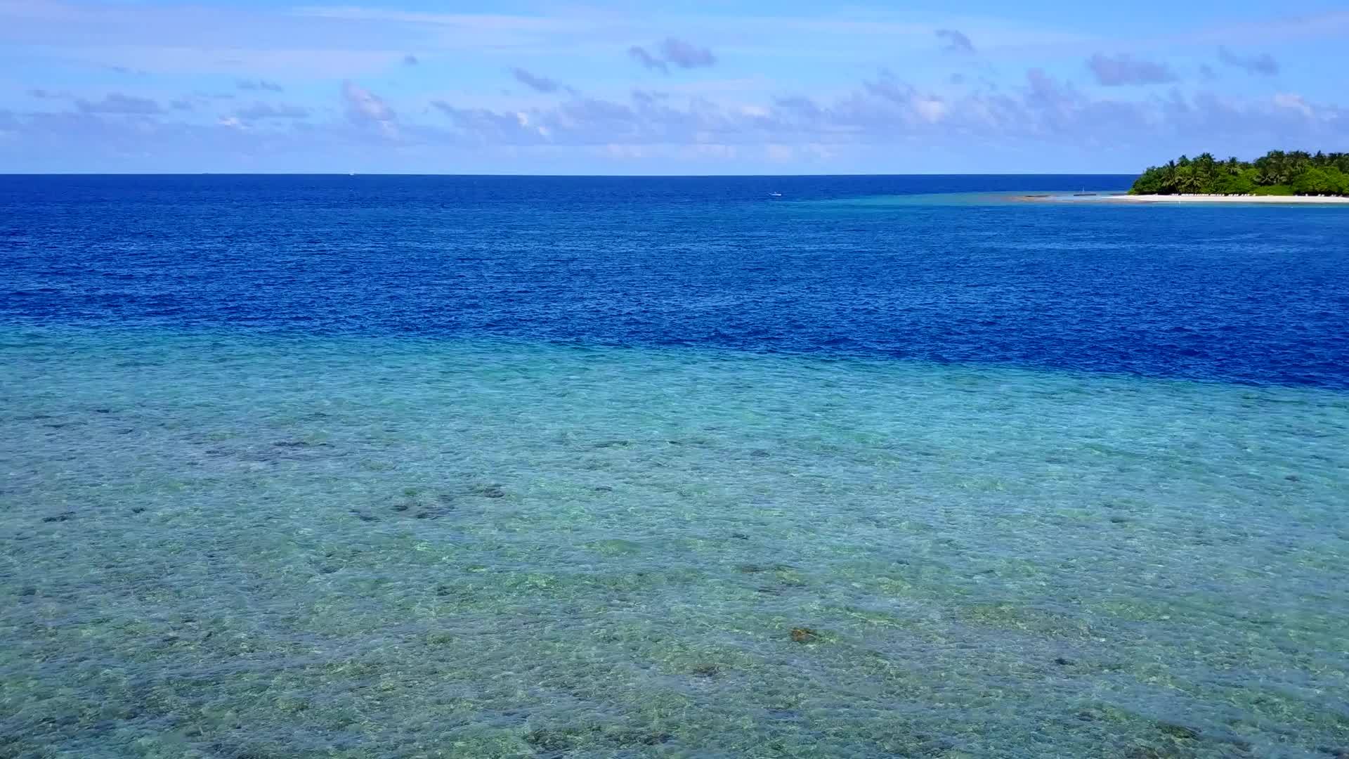 流动的蓝色海洋和接近冲浪的白色沙底背景是空的视频的预览图