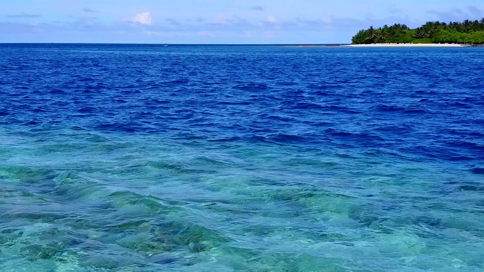 海滩附近的蓝水和白色沙滩背景的蓝水用于外部海滩视频的预览图