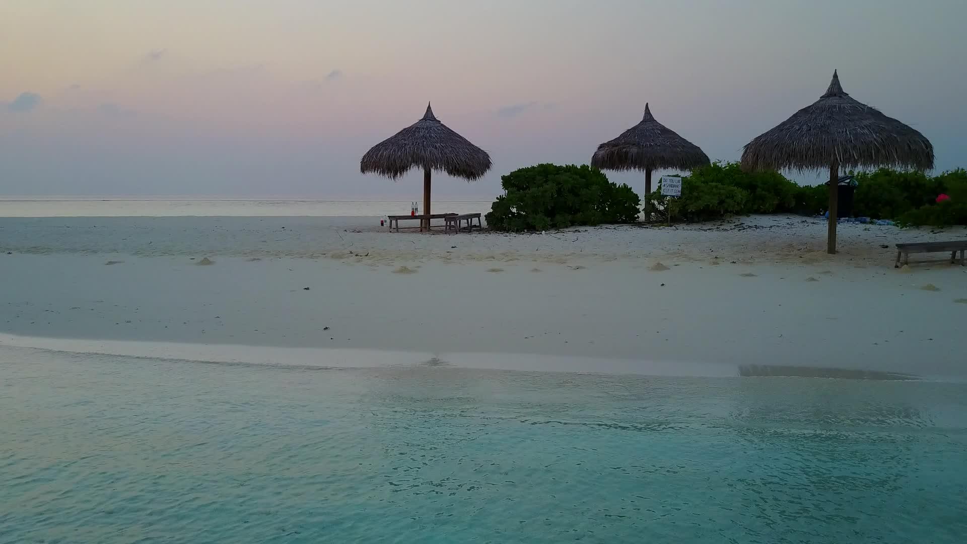 美丽的旅游海滩在棕榈树附近的蓝色海洋和白色海滩上航行视频的预览图