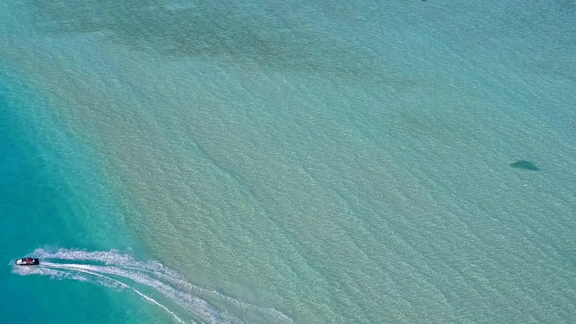 热带度假胜地海滩经过蓝色环礁湖视频的预览图