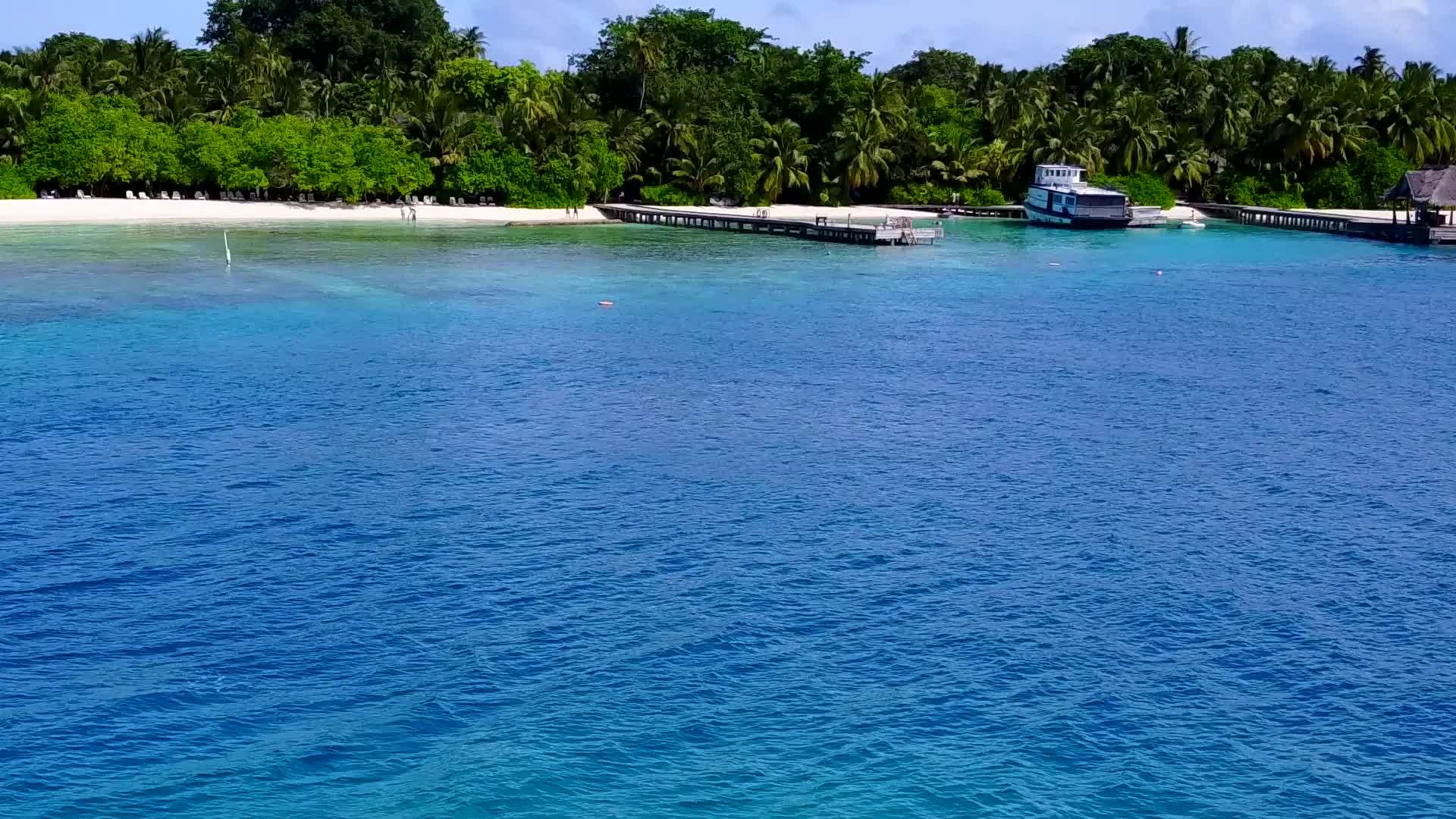 通过蓝海和沙巴附近的白色海滩背景我们可以密切修复宁静的海滩视频的预览图