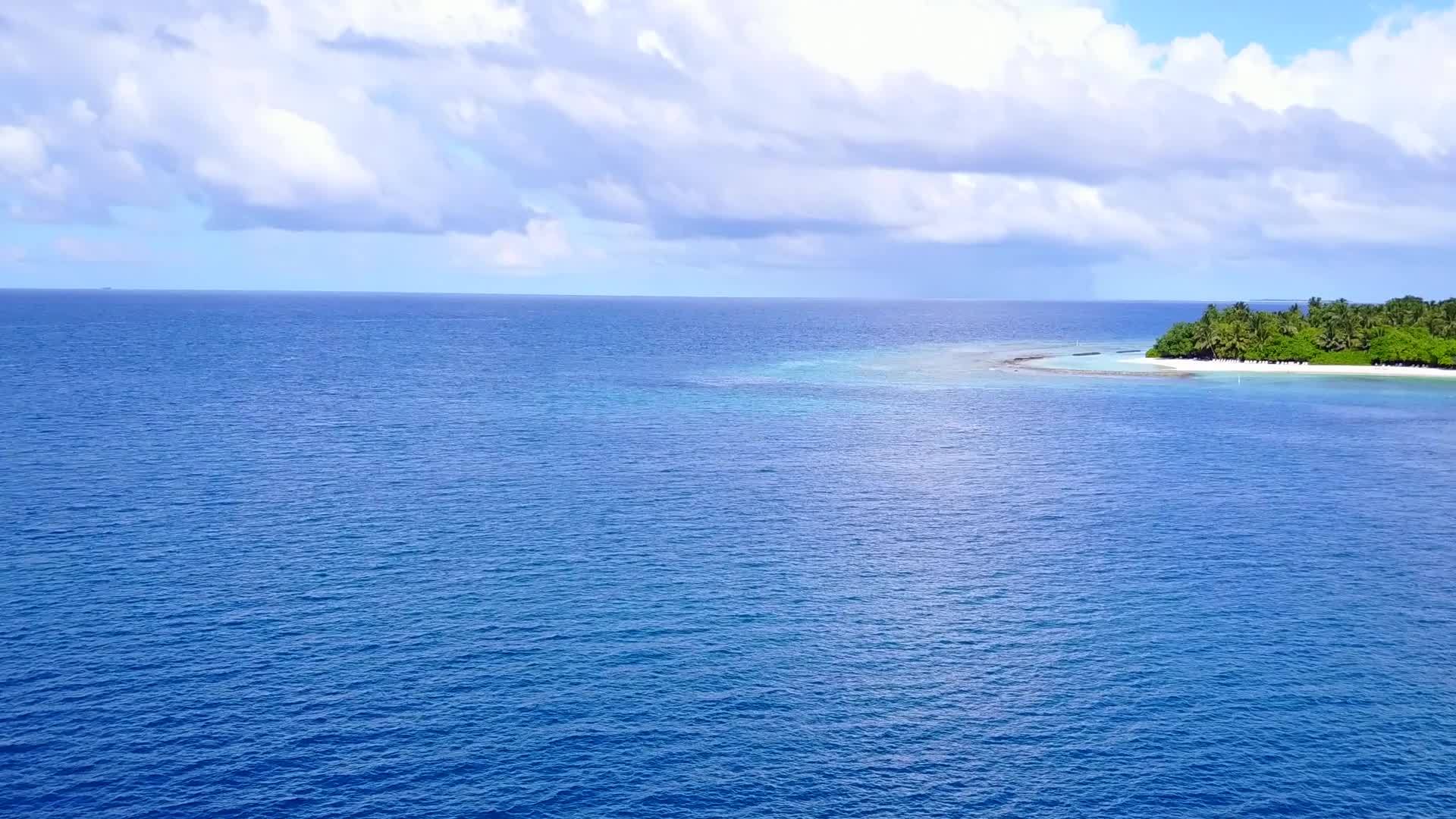 蓝色的海水和白沙在海滩附近的阳光下视频的预览图