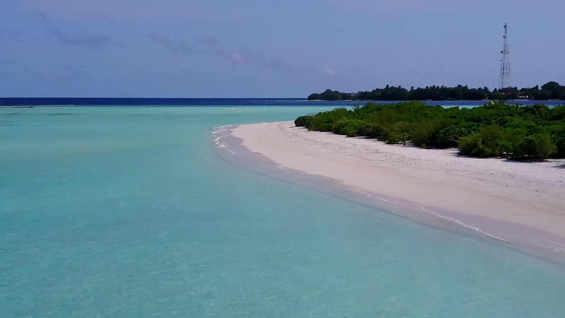 蓝色的海水和白沙在海滩附近的阳光下视频的预览图