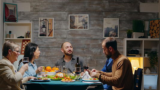 男人和女人在家庭晚餐上喝一杯红酒视频的预览图