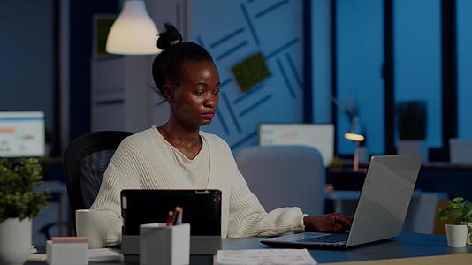 多任务黑人商业女性同时在笔记本电脑和平板电脑上工作视频的预览图