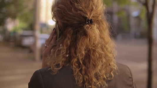 看着一个姜卷发的女人的背视频的预览图