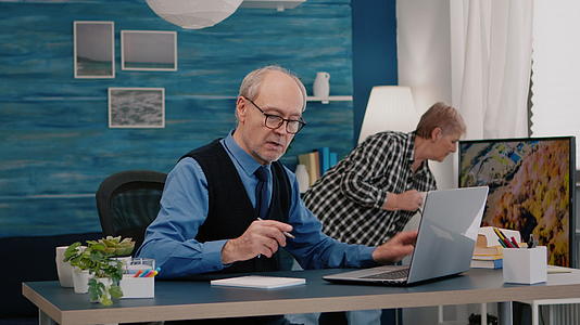 退休男子在笔记本上读书写笔记视频的预览图