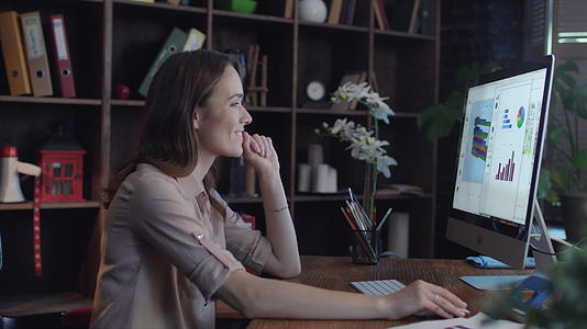 成功的商业女性在电脑屏幕上寻找图表和视频的预览图