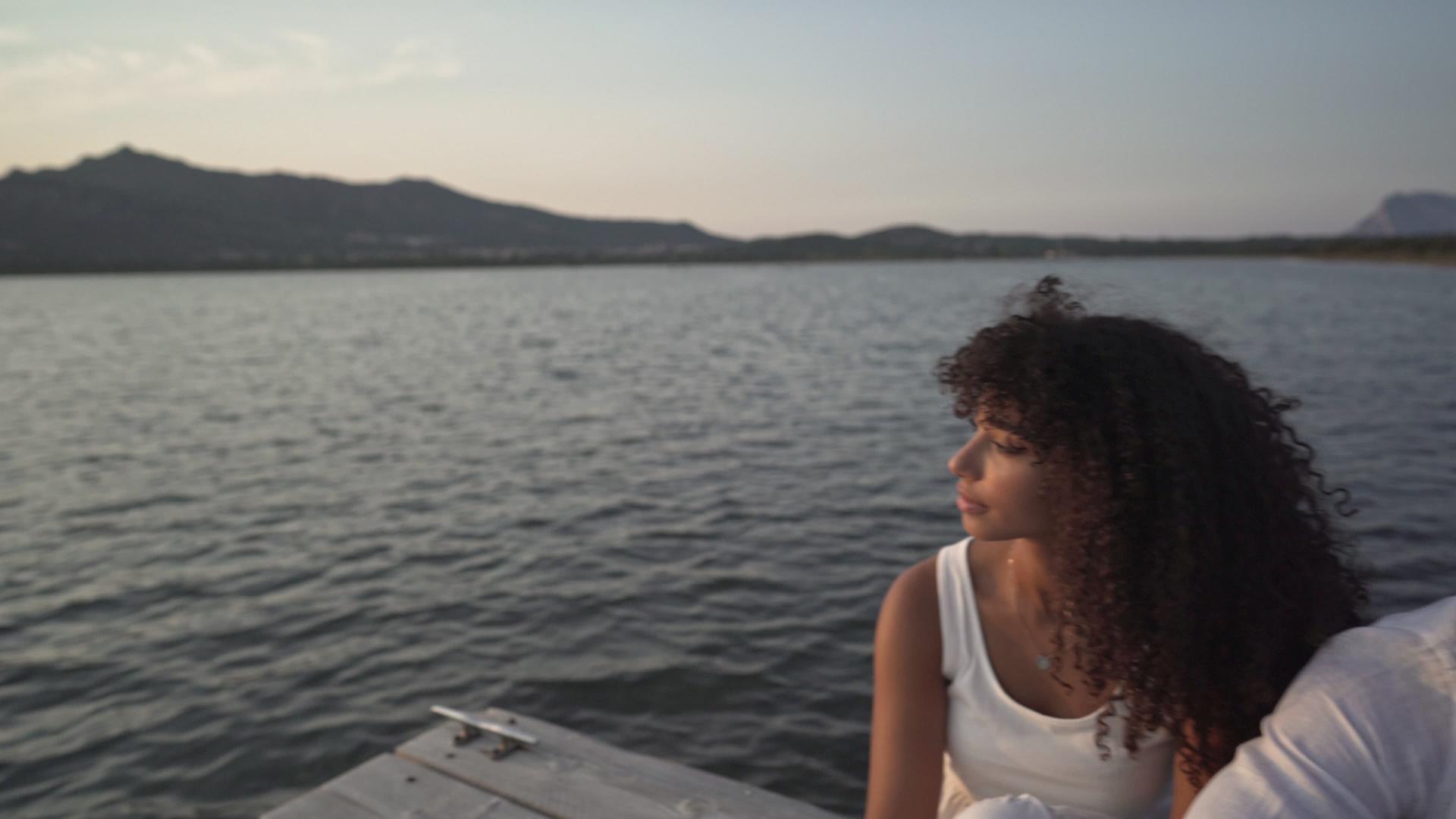 白人年轻人拥抱他的西班牙裔女友日落时在码头上视频的预览图