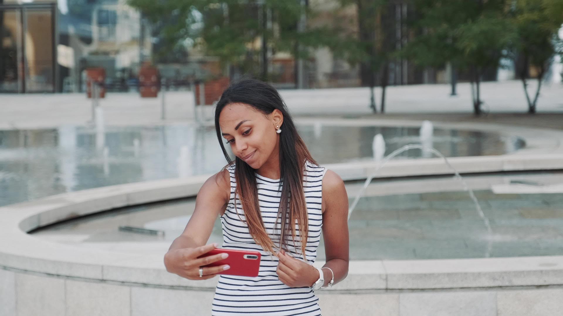 迷人的黑人女人在喷泉前自拍视频的预览图