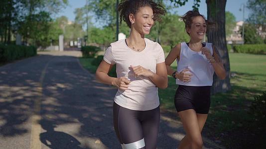 为了保持健康两名年轻可爱的女性在公园里慢跑视频的预览图