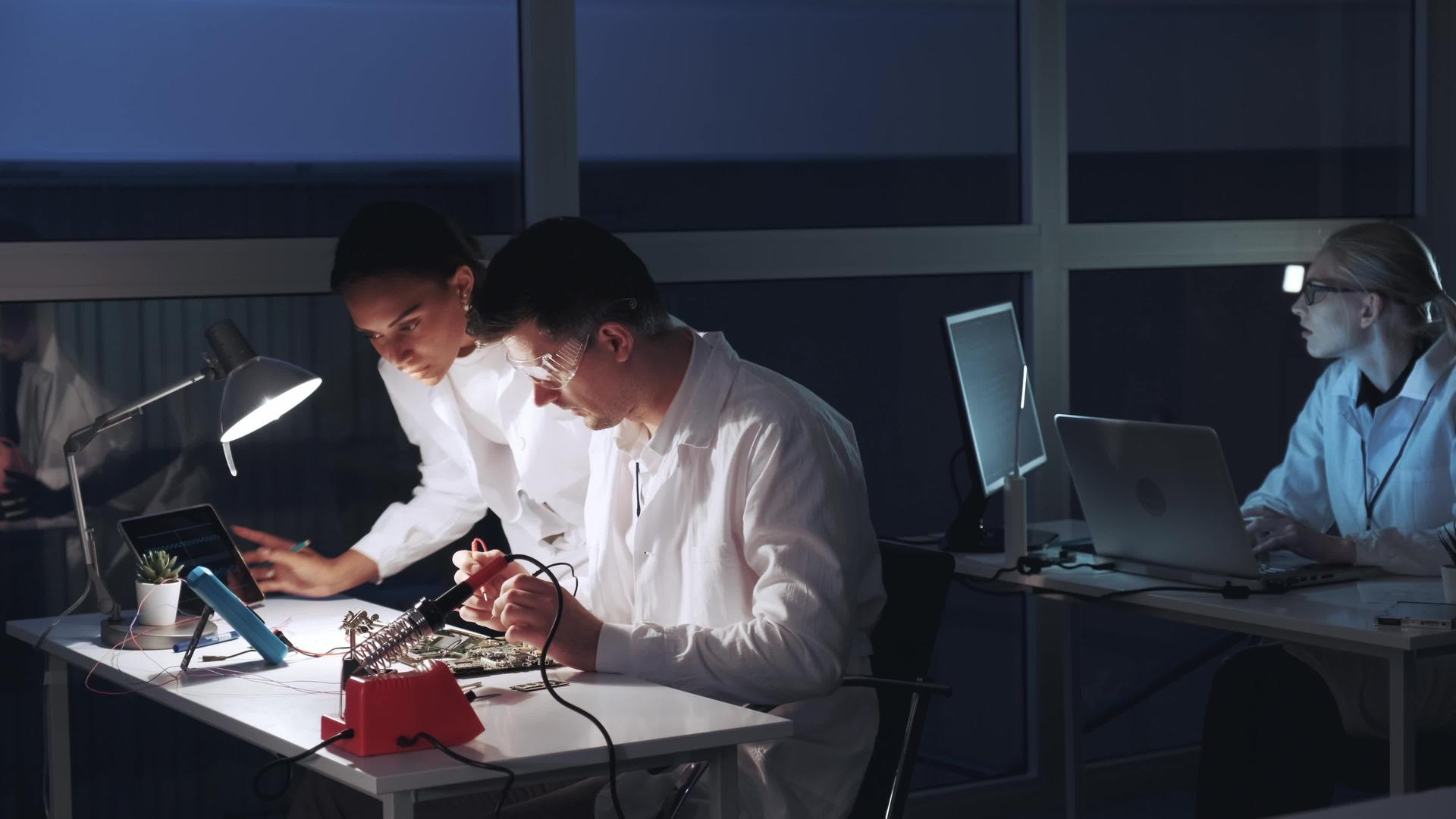 在电子实验室中男女使用多米测试仪检查主板和多米测试仪器视频的预览图