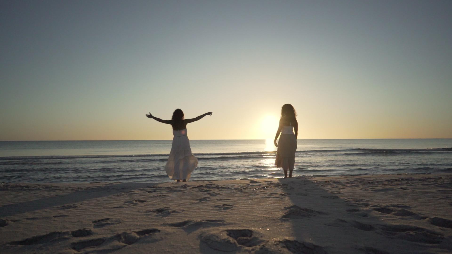 站在海抱生活和自然的女性朋友站在海边 看着太阳视频的预览图