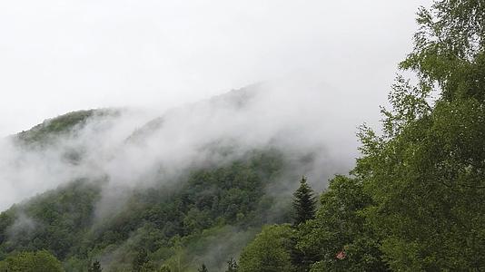 云层在山林中移动风暴笼罩着多云的一天视频的预览图