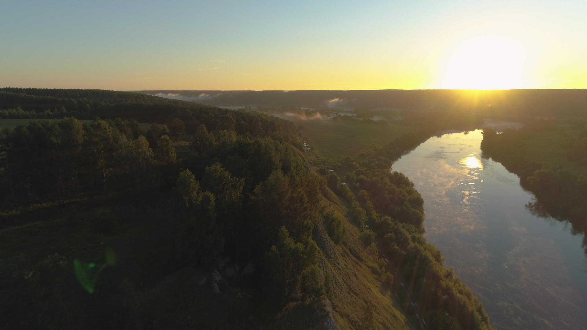 日出时山坡上有树木和河流无人飞机向前飞行视频的预览图