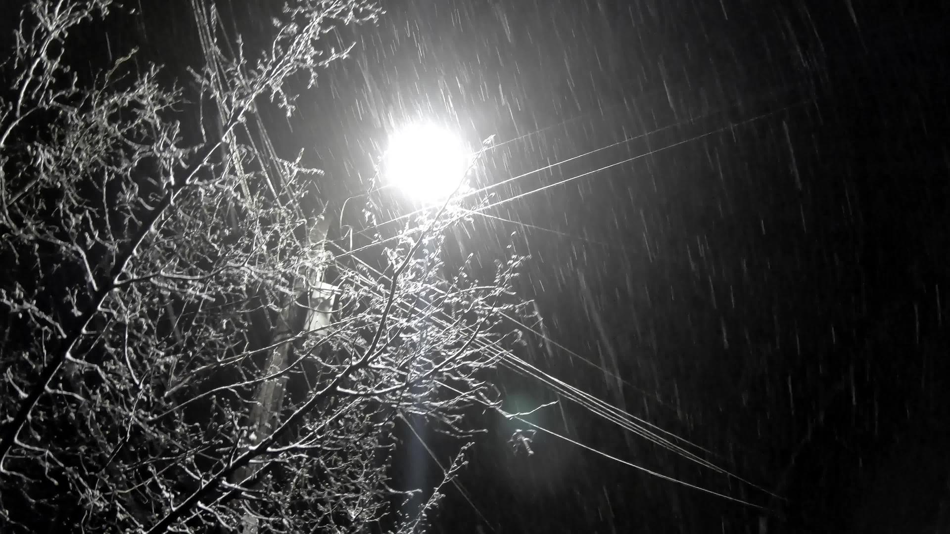 在寒冷的冬天夜晚的雪在街上的城市景观视频的预览图