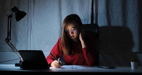 亚洲女性在深夜在家办公室使用平板电脑数字工具工作视频的预览图